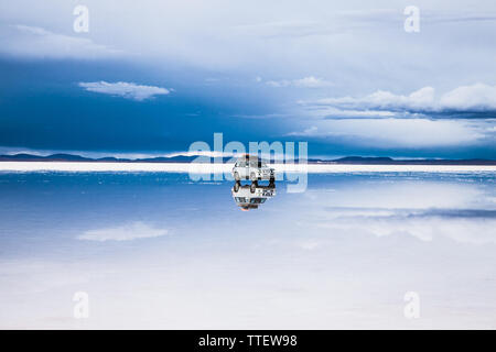 Salar de Uyuni, Bolivia - Dic 31, 2018: Salar de Uyuni in Bolivia coperta con acqua con auto e nuvole riflessioni soft Foto Stock