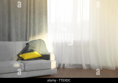 Giallo cuscino decorativo su grigio divano nel soggiorno con mattoni muro  bianco e caffè semplice tabella Foto stock - Alamy