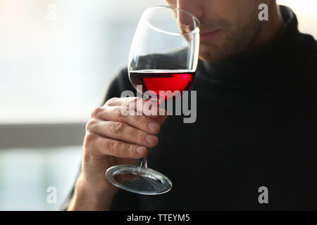 L uomo lo sniffing di vino rosso in un bicchiere, close up Foto Stock