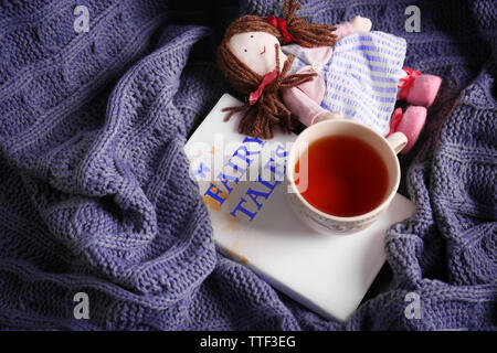 Rag Doll con favole prenota e la tazza di tè su copriletto. Concetto di infanzia Foto Stock