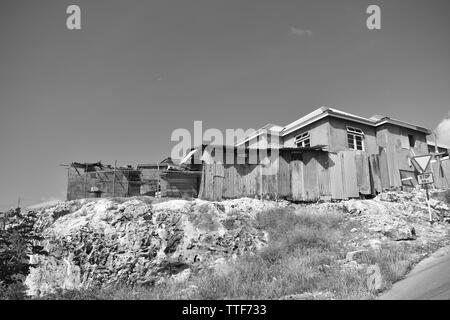 La fotografia in bianco e nero presi in barbados di una corsa verso il basso casa su una collina erbosa Foto Stock