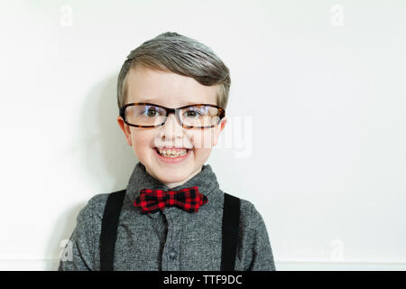 Ragazzo sorridente vestito come un uomo vecchio guardando dritto in telecamera Foto Stock