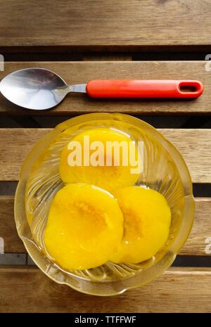 Conserve di pesche sciroppate in recipiente di vetro Foto Stock