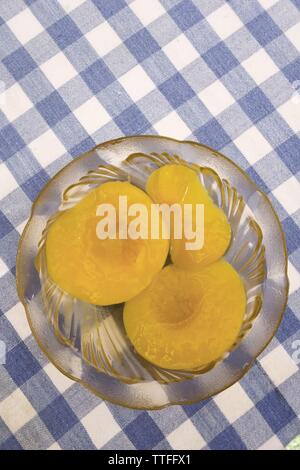 Conserve di pesche sciroppate in recipiente di vetro Foto Stock