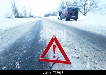 Ripartizione per auto con il triangolo rosso in inverno nevoso road, all'aperto Foto Stock