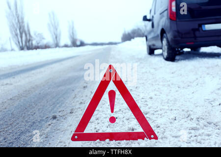 Ripartizione per auto con il triangolo rosso in inverno nevoso road, all'aperto Foto Stock