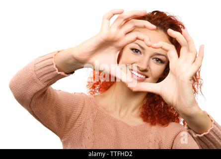 I capelli rossi giovane donna che fa il cuore con le mani, isolato su bianco Foto Stock