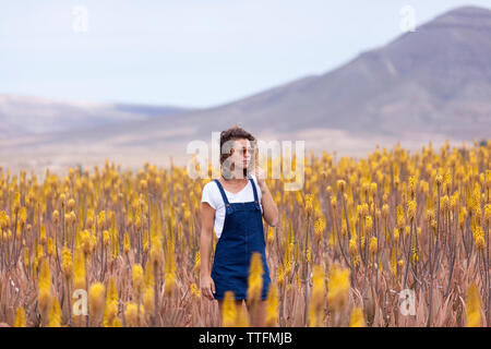 Bella ragazza con occhiali da sole a camminare in aloe vera campo, Fuerteventura Foto Stock