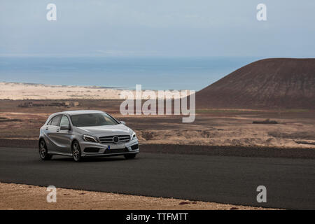 Grigio guida auto vuota strada asfaltata nel deserto paesaggio vulcanico Foto Stock