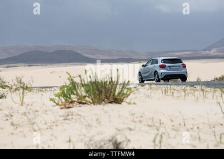 Grigio guida auto vuota strada asfaltata nel deserto paesaggio vulcanico Foto Stock