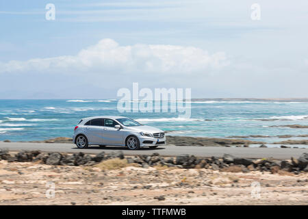 Grigio guida auto vuota strada pavimentata con ocean in background Foto Stock