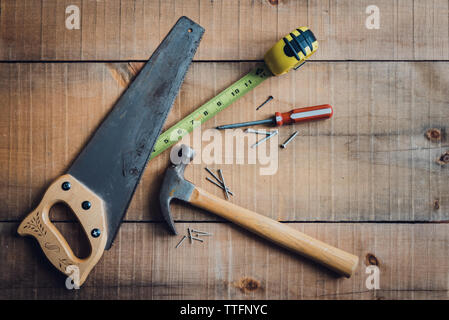 Immagine di overhead di utensili per la lavorazione del legno sparsi su un tavolo di legno. Foto Stock