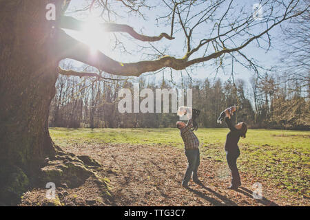 Il padre e la madre gioca con i loro bambini al parco. Foto Stock