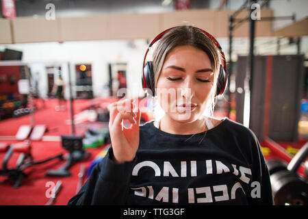 Donna attraente ascoltare musica durante un allenamento in palestra. Foto Stock