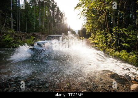 4x4 (SUV Jeep) guidando attraverso il fiume in British Columbia. Foto Stock