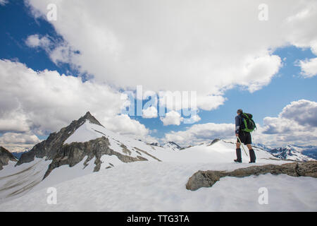 Vista posteriore del montanaro avvicinando il vertice di picco di cipressi, B.C. Foto Stock