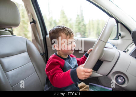 Little Boy fingendo di guidare la macchina Foto Stock