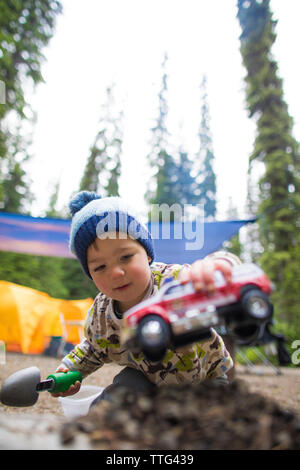 Il Toddler giocando con il carrello e la pala all'esterno. Foto Stock