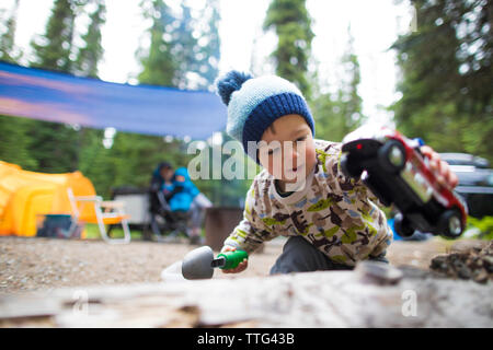 Il Toddler giocando con il carrello e la pala all'esterno. Foto Stock