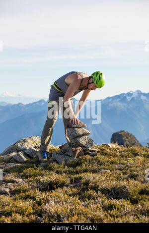 Scalatore edificio rock cairn sul picco di Douglas, British Columbia. Foto Stock