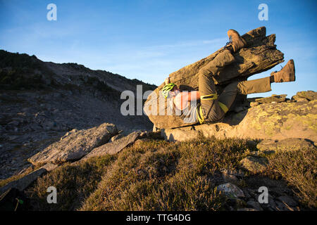 Basso angolo di uomo bouldering su roccia nella costa Mountain Range. Foto Stock