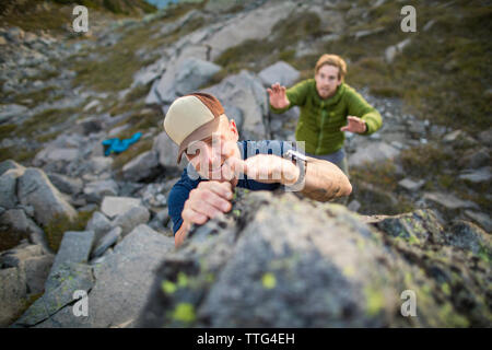 Elevato angolo di visione dell'uomo bouldering con spotter qui di seguito. Foto Stock