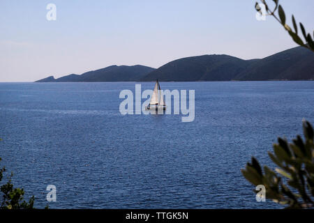 Lonely nave, barca a vela in mare aperto. Mare calmo permette migliori vela in scena pacifica. Piccola imbarcazione a vela sul mare turchese. Bella vista. Foto Stock
