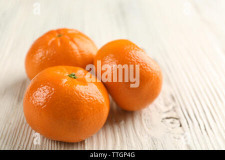 Tre deliziosi piatti freschi con la buccia tangerini sul bianco tavolo in legno, close up Foto Stock