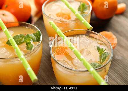 Cocktail con ghiaccio, menta e tangerini sul tavolo di legno, close up Foto Stock