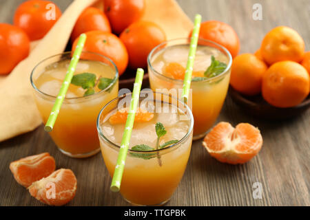 Cocktail con ghiaccio, menta e tangerini sul tavolo di legno, close up Foto Stock