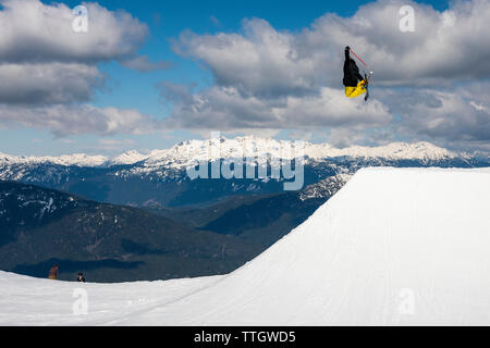 Un uomo colpisce un salto con gli sci nel parco del terreno a Whistler Blackcomb. Foto Stock