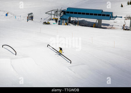 Un uomo colpisce una rotaia su sci nel parco del terreno a Whistler Blackcomb. Foto Stock