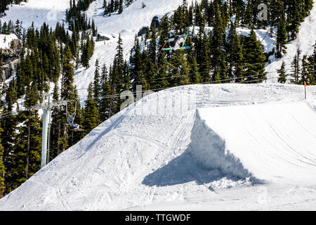 Un uomo colpisce un salto con gli sci nel parco del terreno a Whistler Blackcomb. Foto Stock