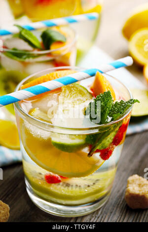 Un cocktail rinfrescante con ghiaccio, menta, i semi di melograno e fette di frutta Foto Stock