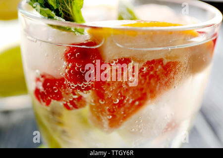 Un cocktail rinfrescante con ghiaccio, menta, i semi di melograno e fette di frutta Foto Stock