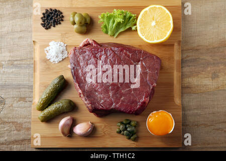 Tartare di manzo ingredienti sul tagliere di legno Foto Stock