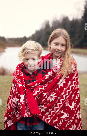 I fratelli avvolto in una coperta di rosso Foto Stock