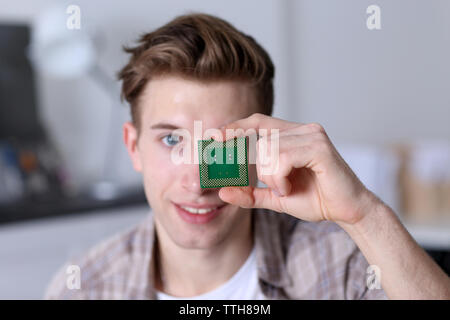 Giovane Azienda del processore del computer vicino a occhio Foto Stock