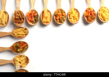 Diversi tipi di pasta secca in cucchiai di legno su sfondo bianco Foto Stock