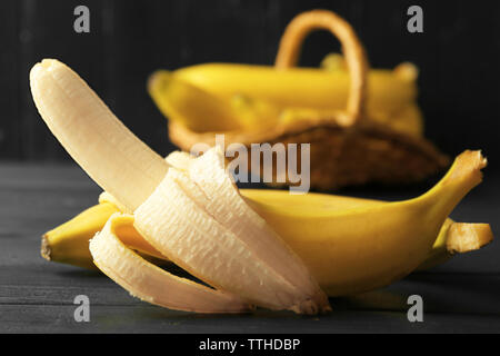 Mezza banana pelata su scuro dello sfondo in legno Foto Stock