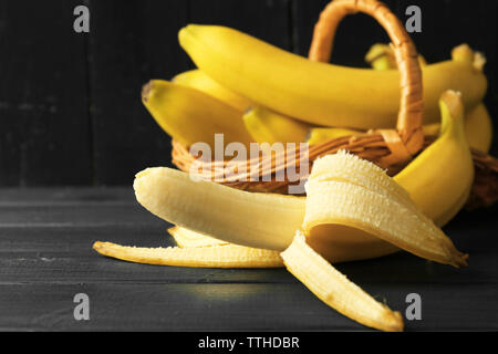 Mezza banana pelata su scuro dello sfondo in legno Foto Stock