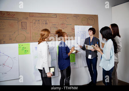 Multi-etnico imprenditrici per discutere la strategia in ufficio creativo Foto Stock