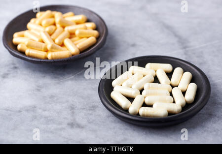 Acido alfa lipoico e coenzima Qio capsule. Rafforzare il sistema immunitario. Concetto per una sana integrazione dietetica. Luminosa sullo sfondo di pietra. Close up. Foto Stock