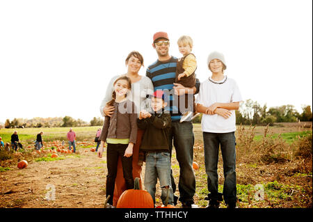 La famiglia felice in piedi presso l'azienda contro il cielo chiaro Foto Stock