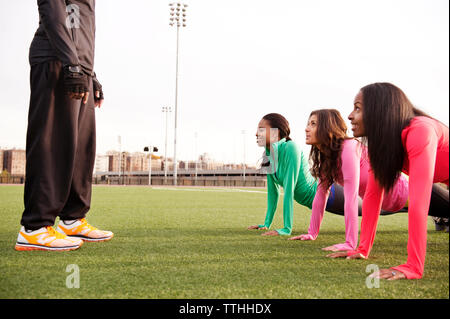 Le atlete di eseguire push-up mentre guardando il trainer Foto Stock