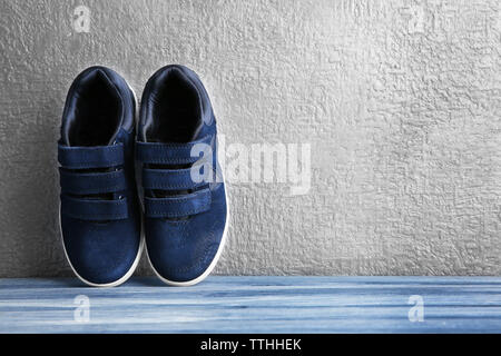 Nero scarpe da ginnastica per bambino su grigio Sfondo testurizzata Foto Stock