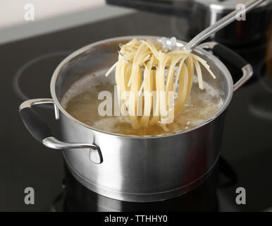 Spaghetti in cucchiaio sui pan closeup Foto Stock