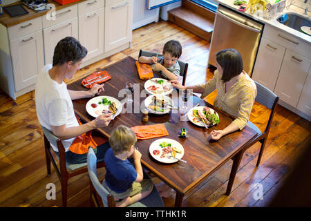 Elevato angolo di visione della famiglia mangiare al tavolo da pranzo in cucina Foto Stock