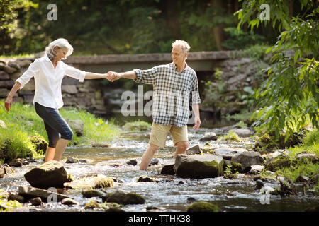 Senior uomo donna che assiste durante il flusso di attraversamento Foto Stock