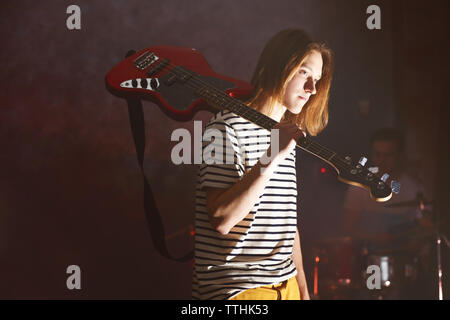 Giovane chitarrista tenendo la sua chitarra elettrica sulla spalla. Foto Stock